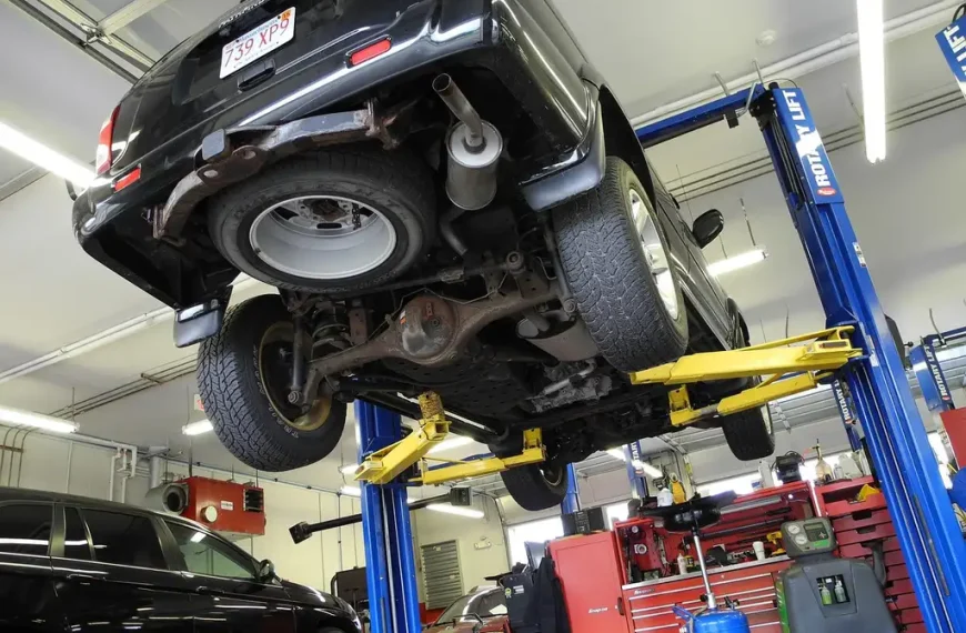 Home mechanic uses a smoke leak detector under a car to find an exhaust leak