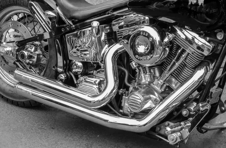 Motorcycles with different exhaust setups parked beside a rider at sunset