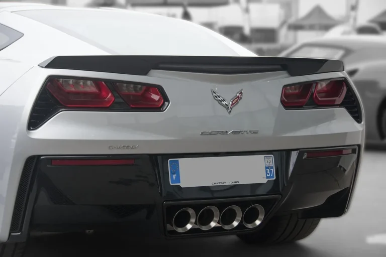 Best exhaust upgrades article scene showing a sport sedan on a lift with a mechanic handling exhaust parts