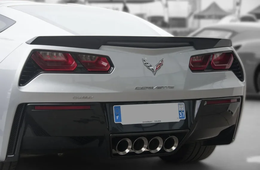 Best exhaust upgrades article scene showing a sport sedan on a lift with a mechanic handling exhaust parts
