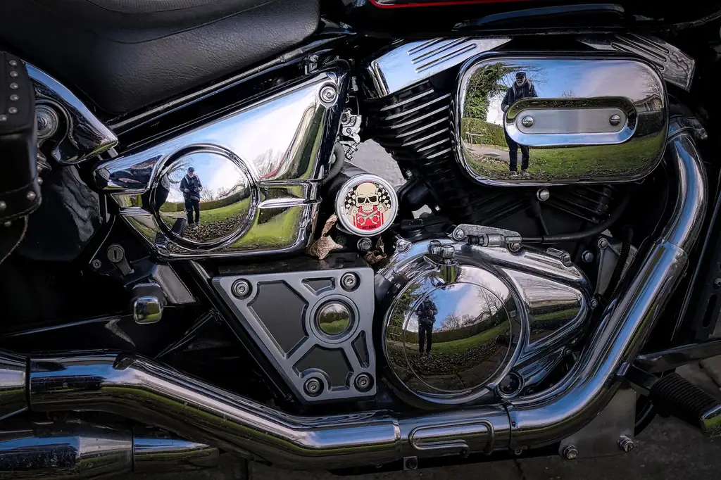 Harley exhaust pipe gaskets and tools beside a V-twin cylinder head on a workbench
