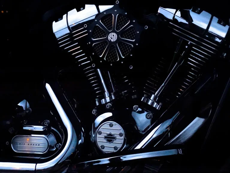 Sport and dual-sport motorcycles with titanium exhausts in a sunlit workshop