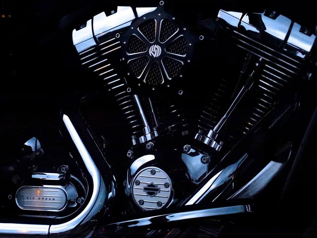 Sport and dual-sport motorcycles with titanium exhausts in a sunlit workshop