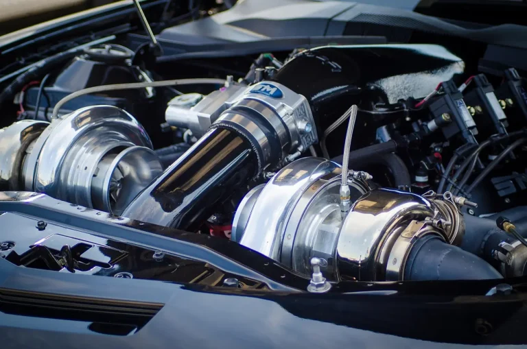 Sports sedan on a lift showing the exhaust path from midsection to rear section in a garage