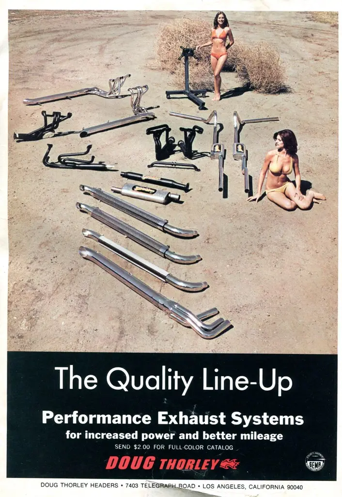 Close-up of a catalytic converter and muffler on a workbench with gloved hands