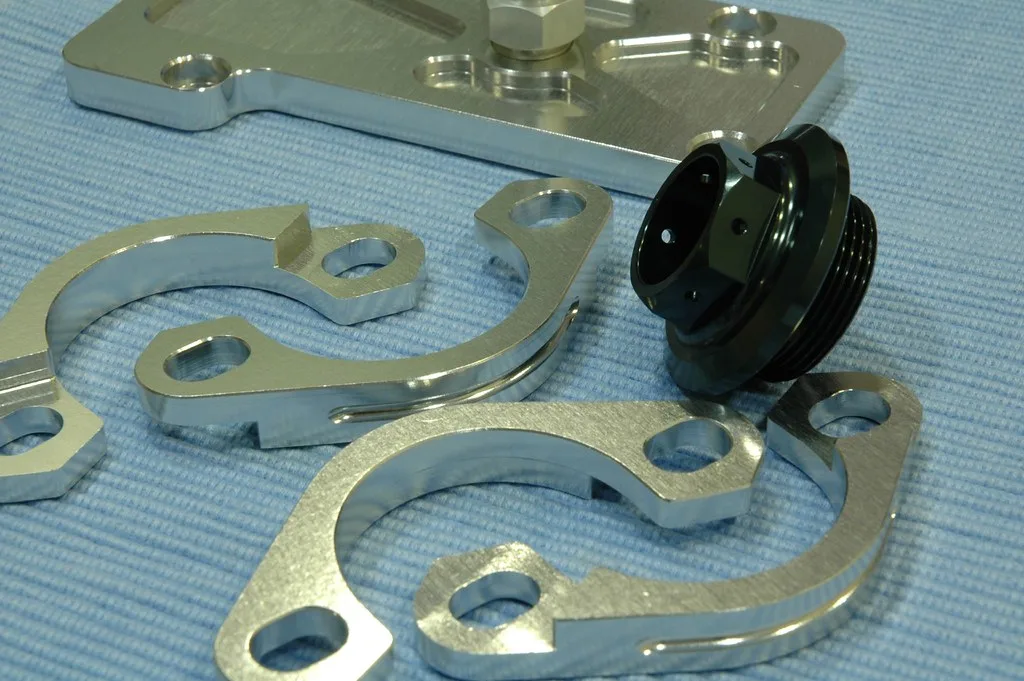 Close-up of an exhaust flange, gasket, and sealant residue on a workbench
