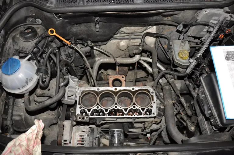 Exhaust gaskets and seals laid out beside a rusted exhaust flange on a mechanic's bench