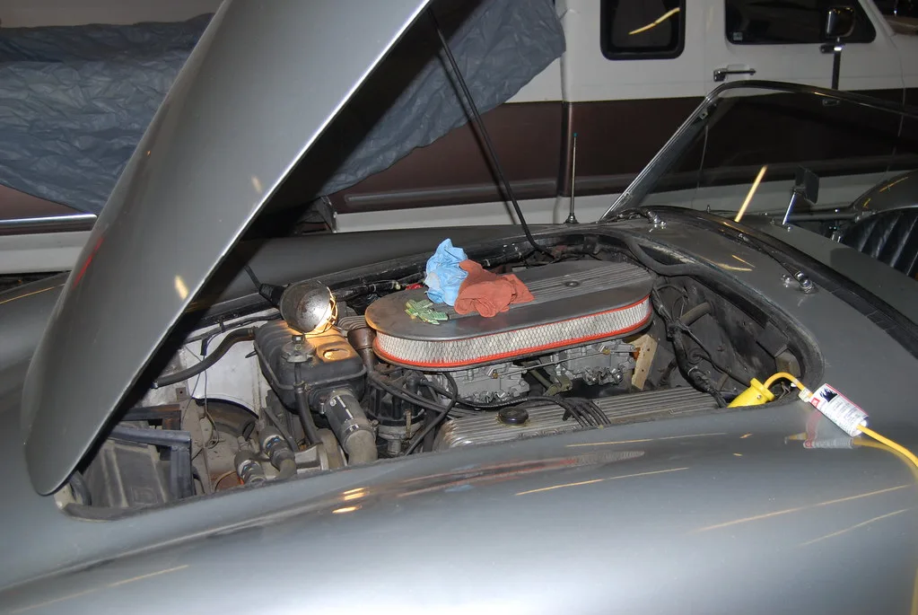 Mechanic comparing a flat exhaust gasket and a donut-style seal with a caliper