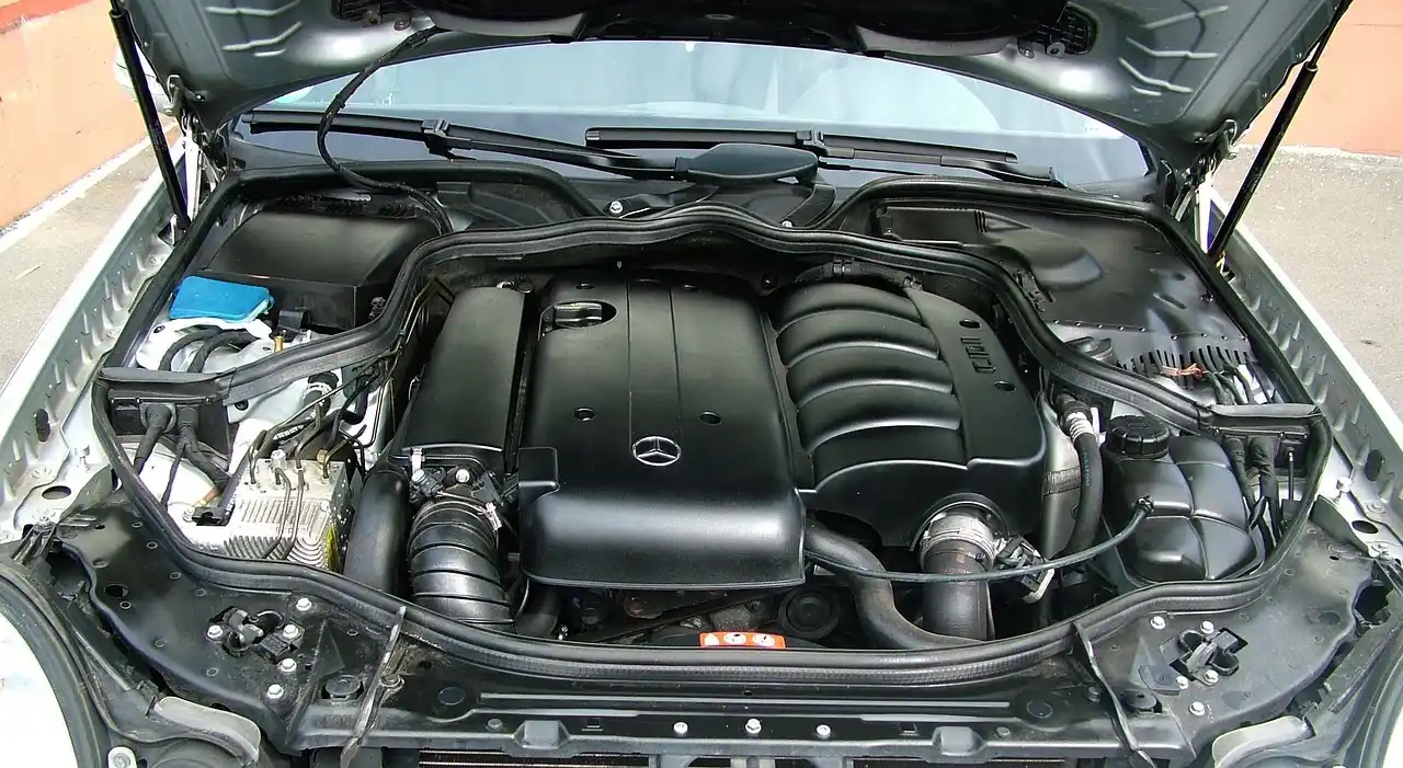 Car engine bay showing exhaust manifold and intake manifold on opposite sides of the engine