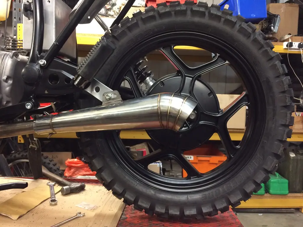Close-up of exhaust reducer and expander fittings beside matching pipe ends.