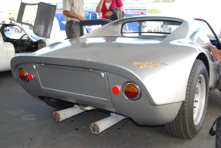 Mechanic inspecting a car exhaust resonator under a lifted vehicle