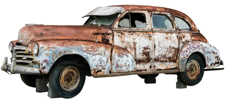 Mechanic inspecting a rusted exhaust pipe under a car on a lift