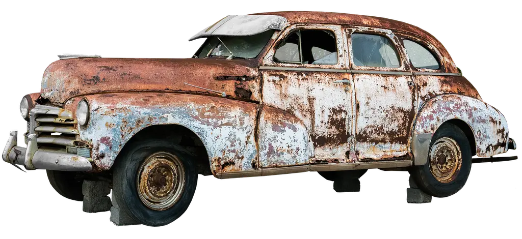 Mechanic inspecting a rusted exhaust pipe under a car on a lift